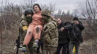 אירפין אוקראינה אישה נישאת על ידי חיילים אוקראינים חוצה שביל מאולתר ב זמן ש היא בורחת מ העיירה אירפין אוקראינה משבר מלחמה רוסיה 