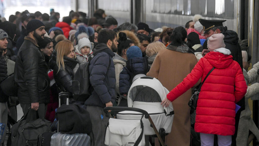 פליטים מאוקראינה בתחנת הרכבת במולדובה, עולים לרכבת המשך לרומניה