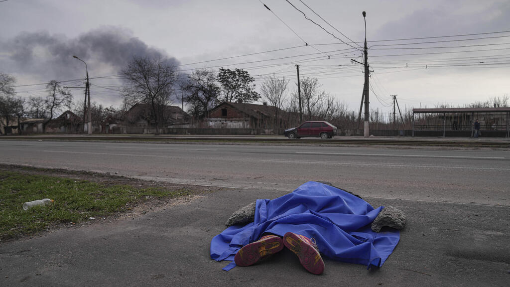 A body lies in the street in Mariupol on Monday 