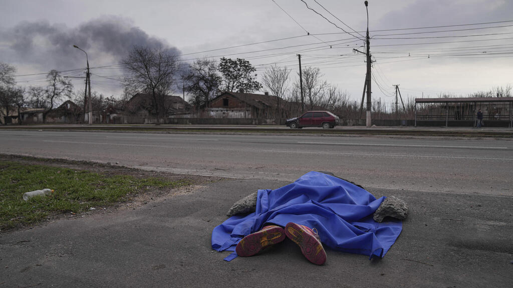 A body lies in the street in Mariupol on Monday 