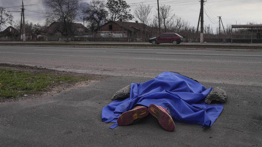A body lies in the street in Mariupol on Monday 