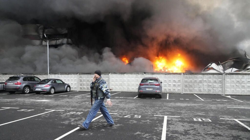 fire and smoke rises over a damaged logistic center after shelling in Kyiv 