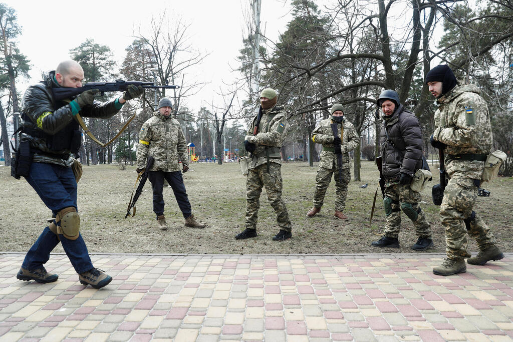 Volunteers perform weapon drills (Photo: Reuters) מדריך מדגים שימוש בנשק בקייב