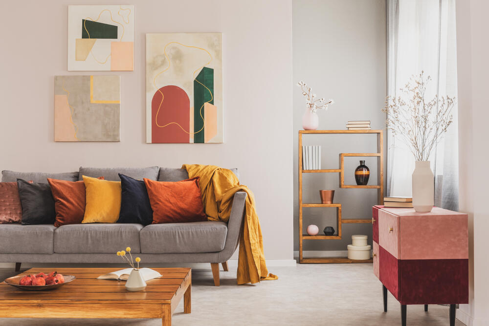 Яркие подушки на диване, мебель нейтральных цветов и репродукции на стену - уют обеспечен 