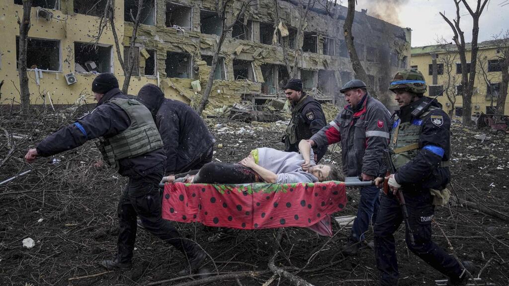  A pregnant woman is taken away from destruction caused by Russian bombing in Mariupol 