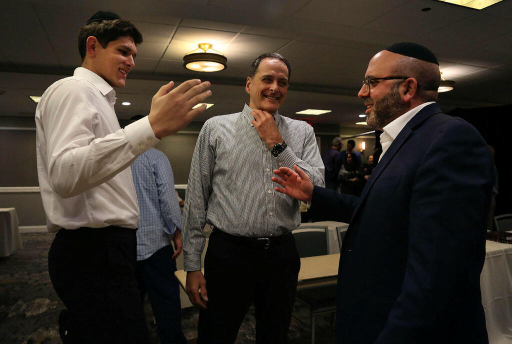 Yeshiva Maccabees' Gabriel Leifer, left, talks with men's basketball assistant coaches Joseph Schwartz and Yoni Cohen at the conclusion of Shabbat 