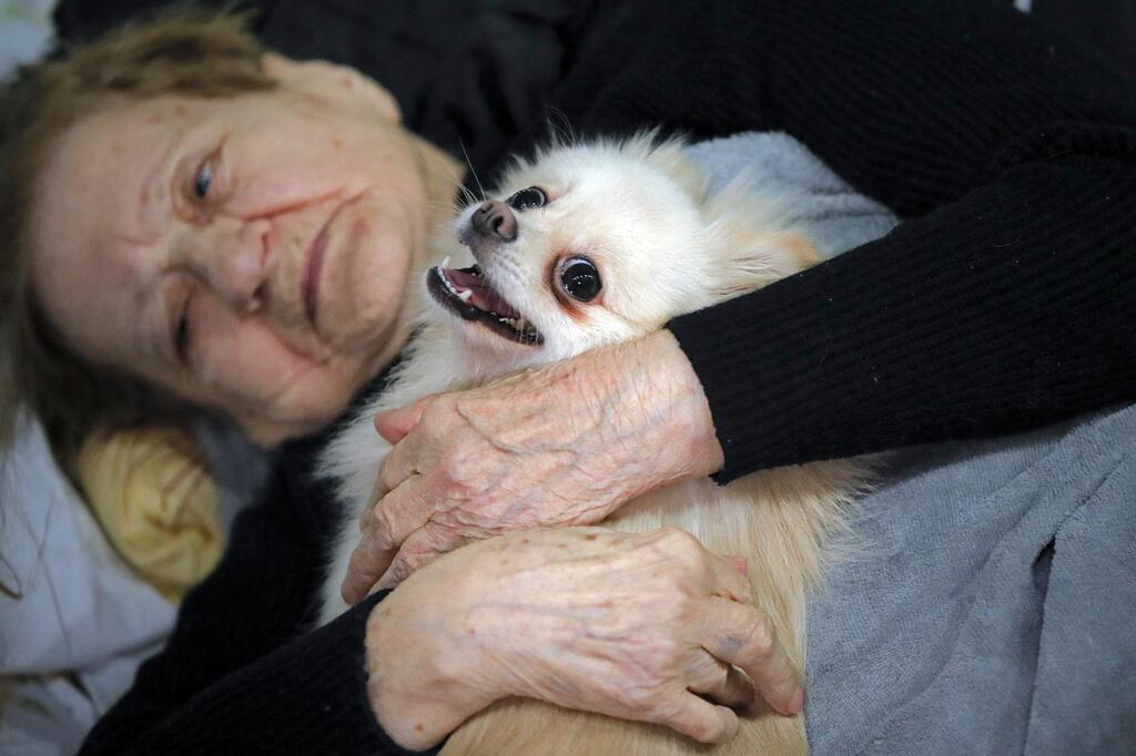 A refugee who fled the Russian invasion from neighboring Ukraine comforts her dog 