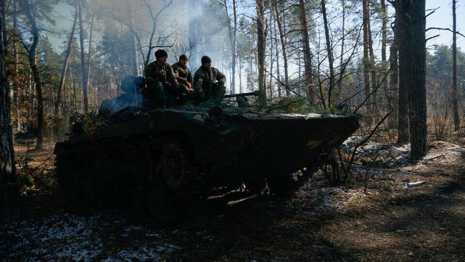 Members of the Ukrainian forces sit on a military vehicle amid Russia's invasion of Ukraine, near Demydiv