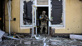 קייב חייל אוקראיני יוצא מבניין שניזוק בעקבות הפגזה משבר מלחמה רוסיה אוקראינה 