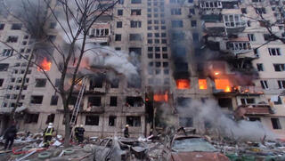  כוחות הצלה מחלצים אזרחים מ בניין בוער שנפגע מהפגזות בקייב