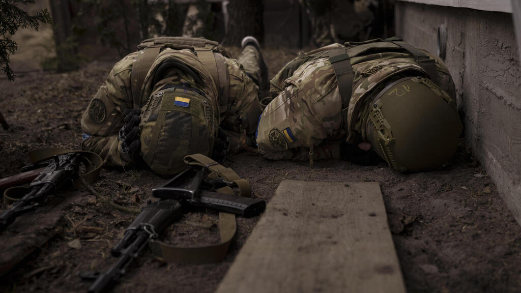 Ukrainian soldiers hiding from shelling near Kyiv (Photo: AP) חיילים בצבא אוקראינה מתגוננים לאחר הפגזה בפאתי קייב