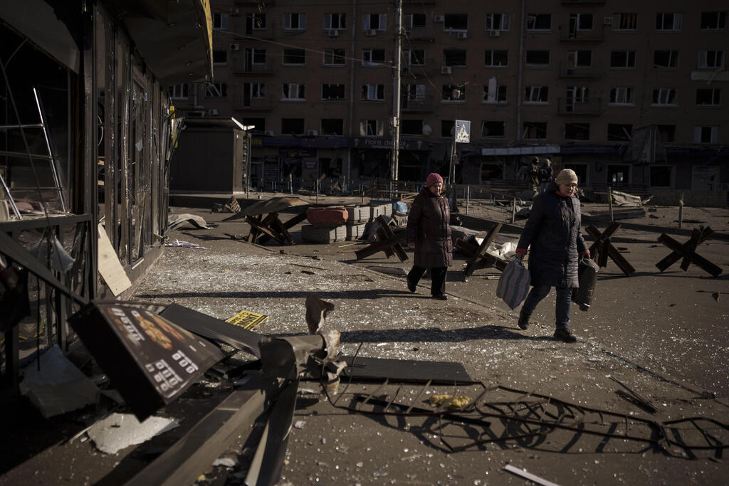 Residents of Kyiv walking by debris caused by Russian shelling  