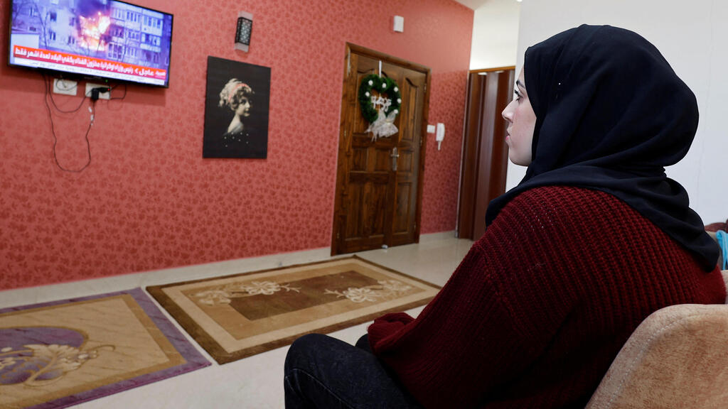Palestinian university student Samar Aita, who studied in Ukraine, watches news about Ukraine's invasion by Russia at her house, in Rafah in the southern Gaza Strip