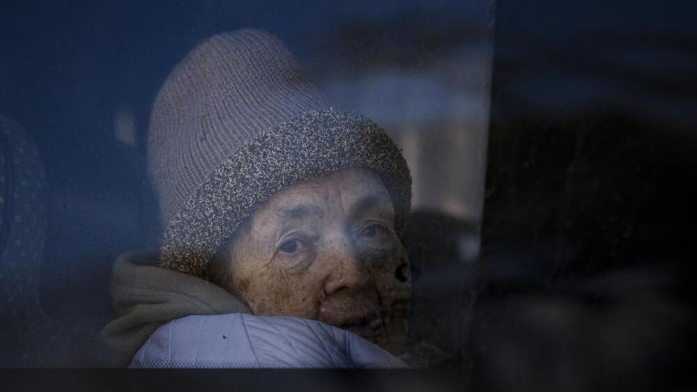 A refugee fleeing the war from neighbouring Ukraine looks out a bus window after crossing the border, at the Romanian-Ukrainian border