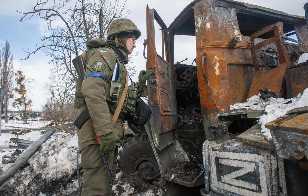 חייל אוקראיני ליד רכב צבאי רוסי הרוס ב חרקוב אוקראינה מלחמה באירופה משבר פלישה רוסיה