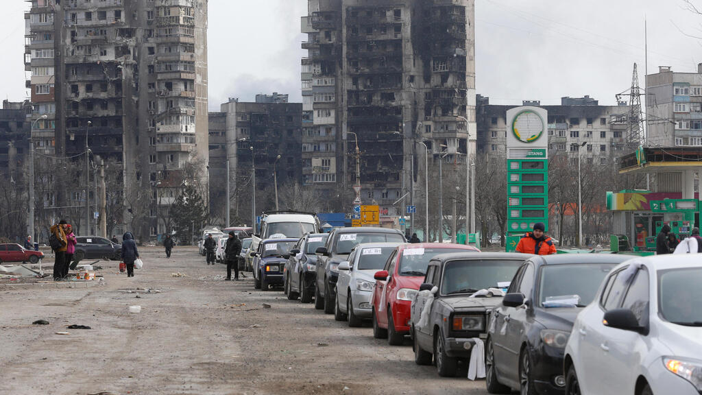 אזרחים רכבים מכוניות עוזבים את מריופול אוקראינה הרס הפגזות נזק תקיפות מלחמה באירופה משבר פלישה