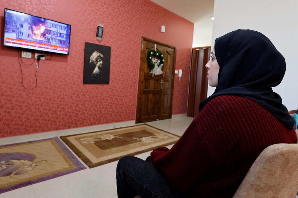 Samar Aita, who studied in Ukraine, watches news about Ukraine's invasion by Russia at her house, in Rafah