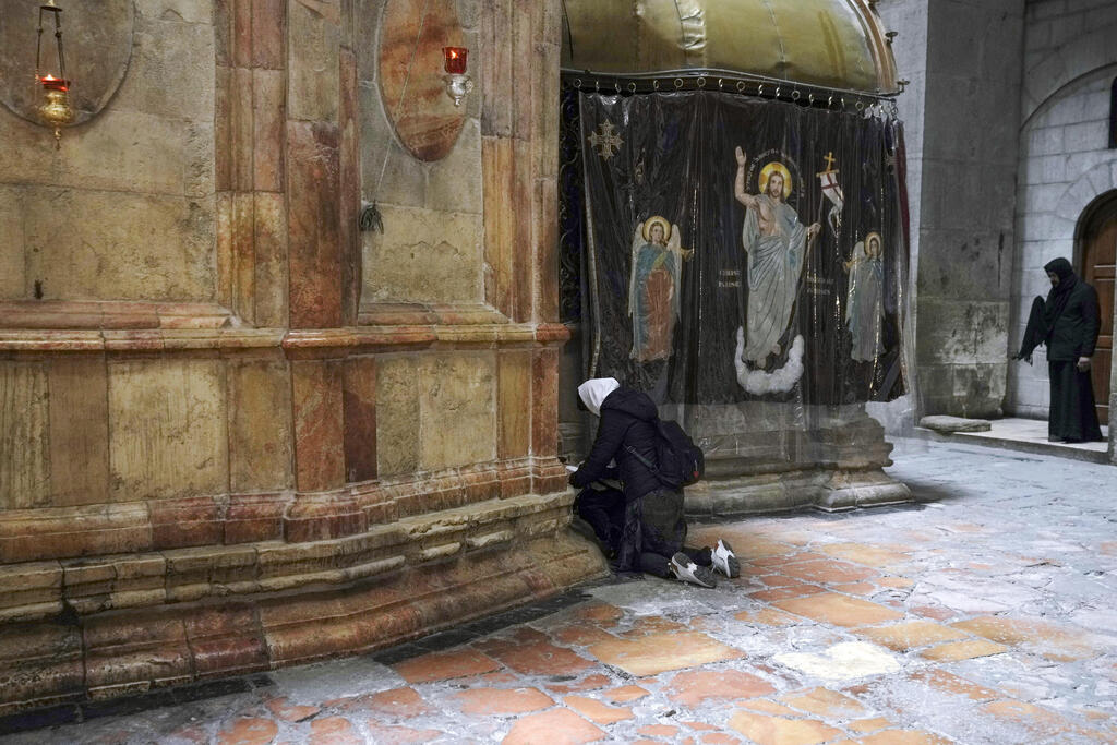A woman prays at the Church of the Holy Sepulcher, in the Old City of Jerusalem, March 17, 2022