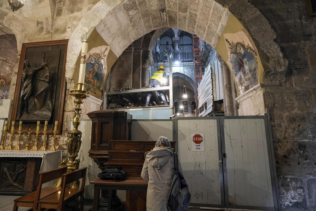 A member of the restoration team works on the floor of the Church of the Holy Sepulcher, in the Old City of Jerusalem, March 17, 2022