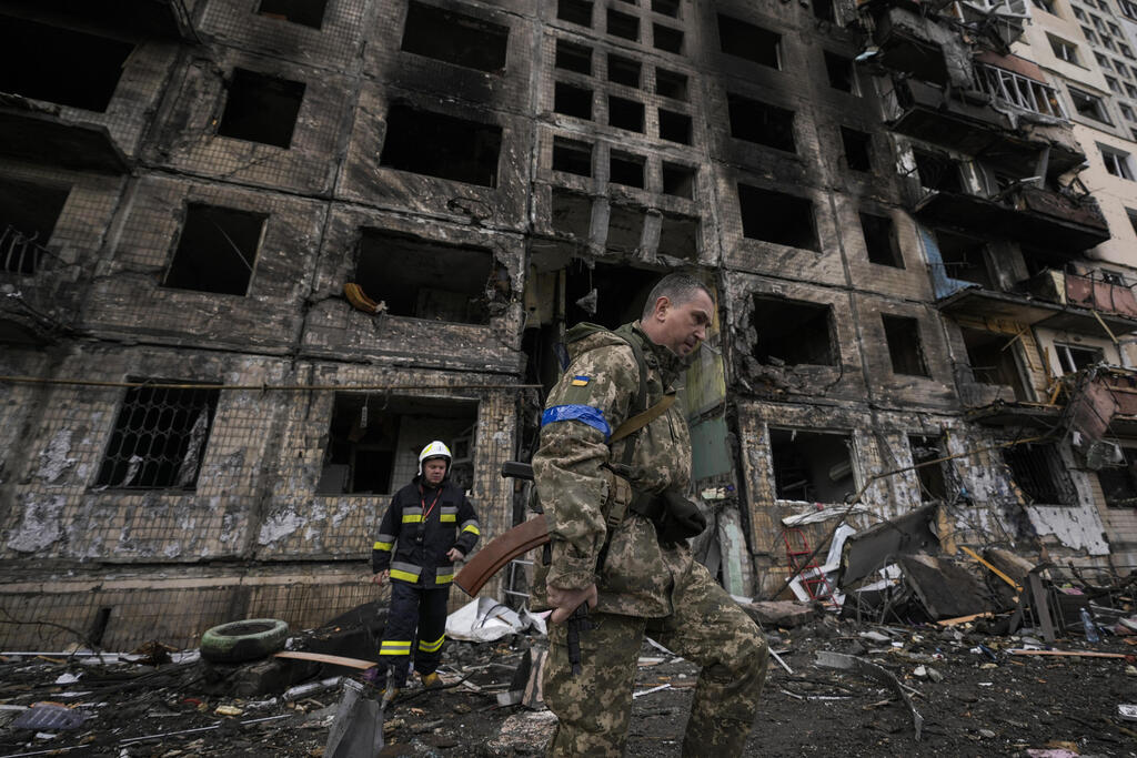 A Ukrainian soldier walked by a building destroyed by Russian bombing in Kyiv 