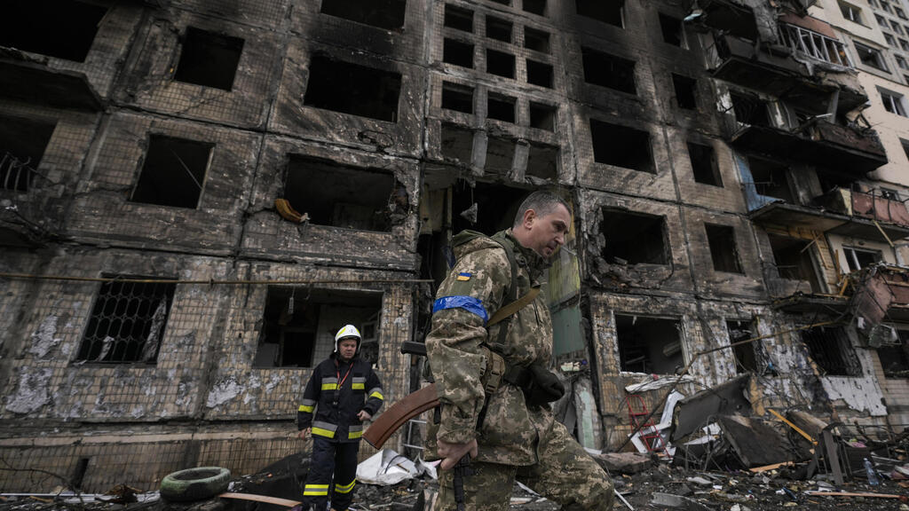 A Ukrainian soldier walked by a building destroyed by Russian bombing in Kyiv 