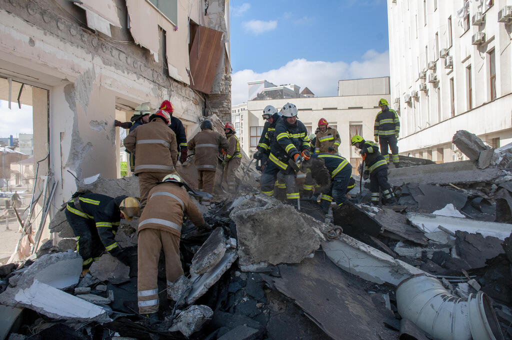 Ukrainian rescuers rummage through debris of building damaged in Russian shelling, in Kharkiv, Ukraine (Photo: EPA) כוחות הצלה בחרקוב, אוקראינה
