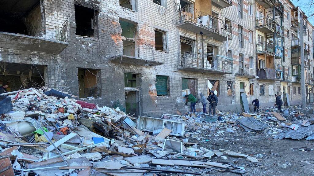 Municipal workers and volunteers remove debris of a damaged residential building, as Russia's attack on Ukraine continues, in Kharkiv