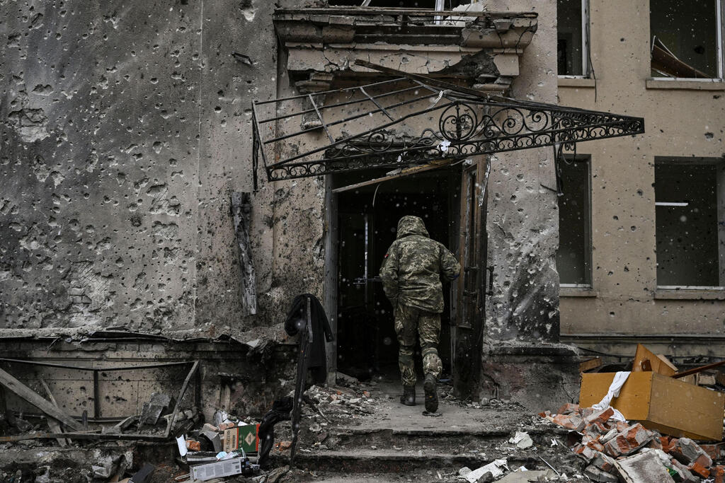 A Ukrainian serviceman walks into the destroyed regional headquarters in Kharkiv on Sunday 