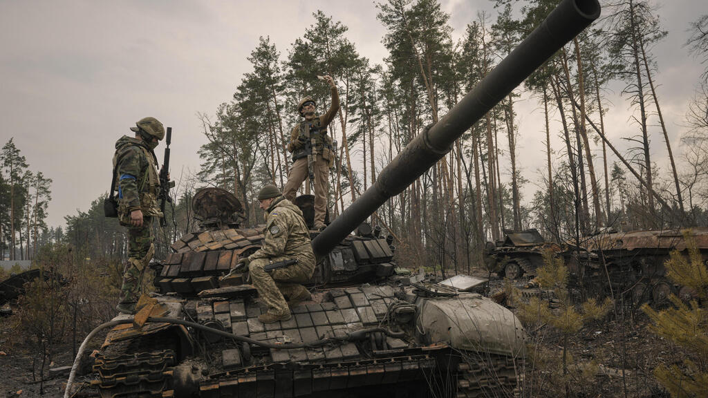 חייל אוקראיני מצלם סלפי על טנק רוסי