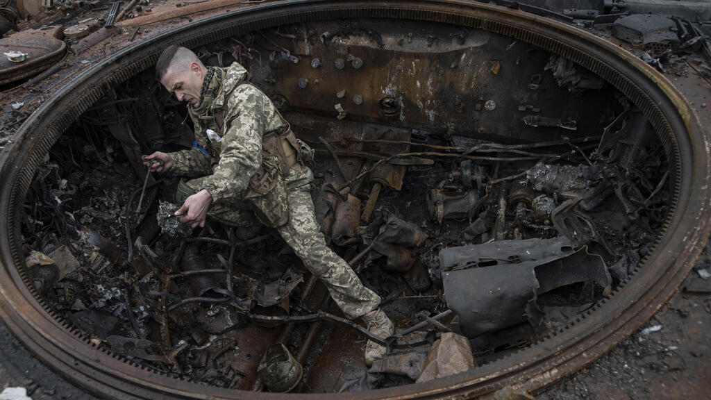 A Ukraine soldier inspects Russian armor after the invasion army withdrawal from the area of Kyiv 