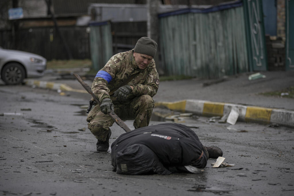 Ukraine Soldier inspects body for boobytrap in a Kyiv Suburb after Russian withdrawal 