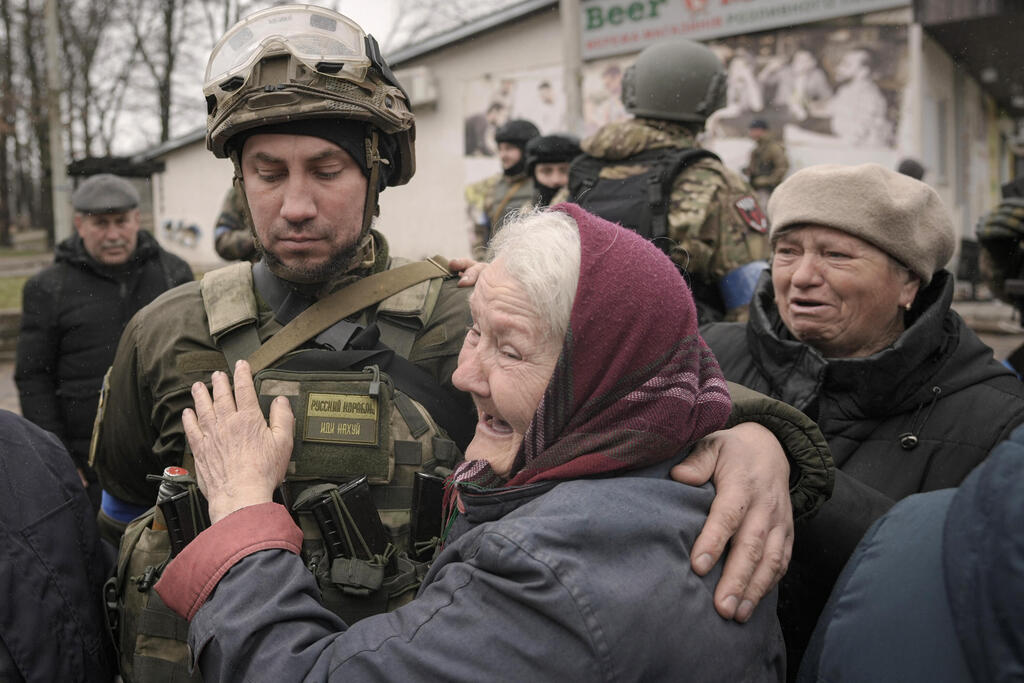 A woman hugs a Ukrainian soldier after the Russian withdrawal from the outskirts of Kyiv 