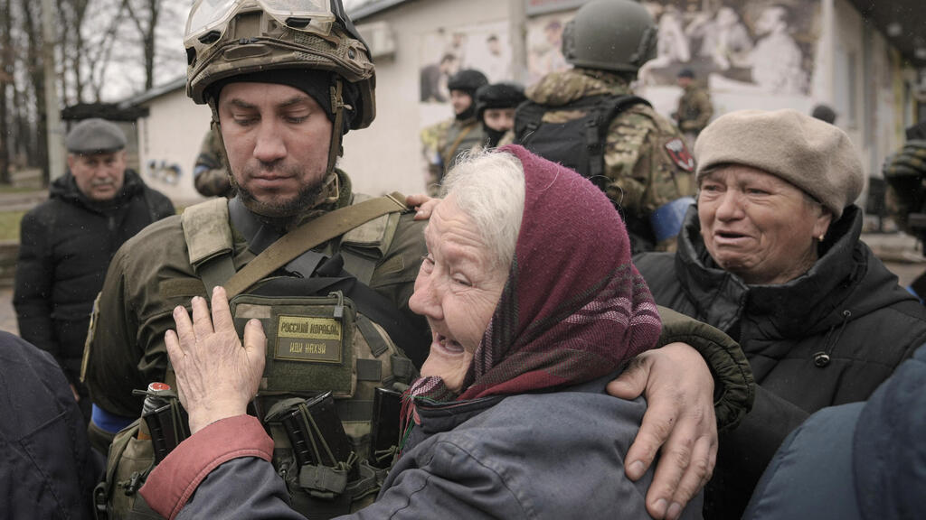 A woman hugs a Ukrainian soldier after the Russian withdrawal from the outskirts of Kyiv 