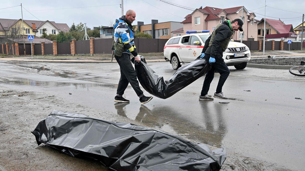 People hauling bodies in the Ukrainian city of Bucha (Photo: AFP) פינוי גופות בבוצ'ה