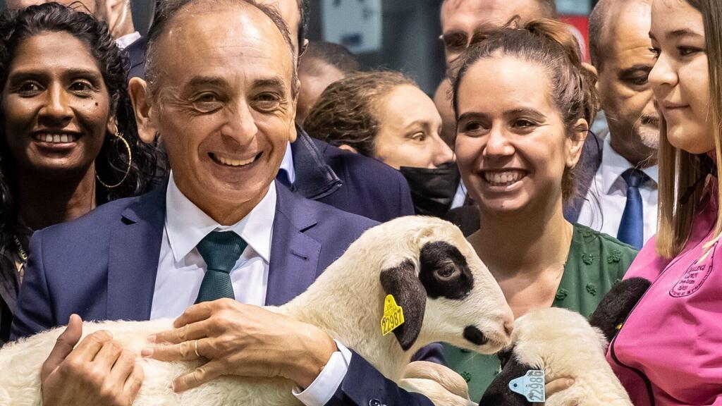 Zemmour holds a lamb as Knafo stands by