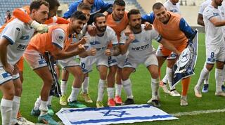 שחקני הפועל פ"ת חוגגים עם דגל ישראל