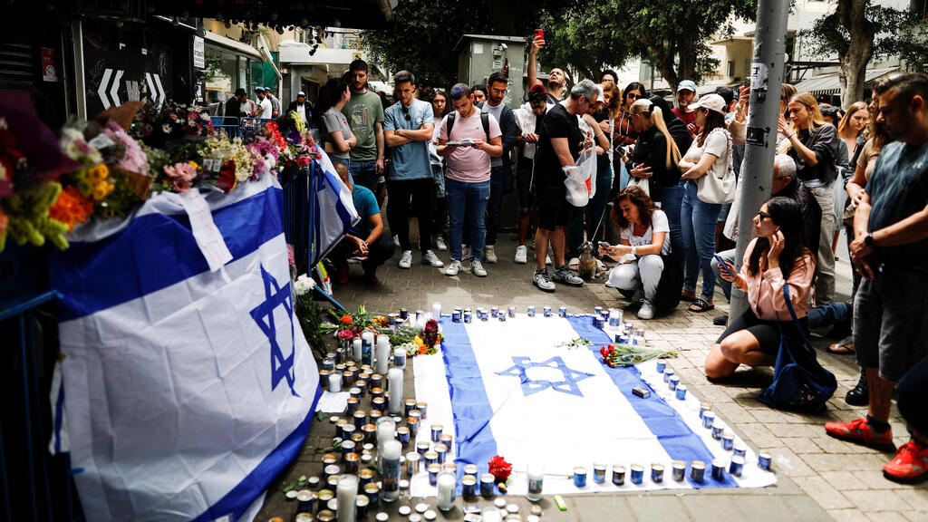 Israelis gather at the spot of a terror attack in Tel Aviv (Photo: Reuters) אנשים הגיעו להדליק נרות ולהניח פרחים בזירת הפיגוע