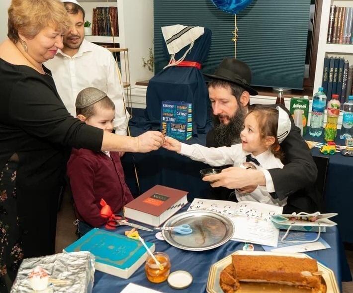 הרב קורבסקי ב"חלאקה" של רומה יליזרוב בן ה-3. לצידם האבא דניאל והסבתא זומרוד