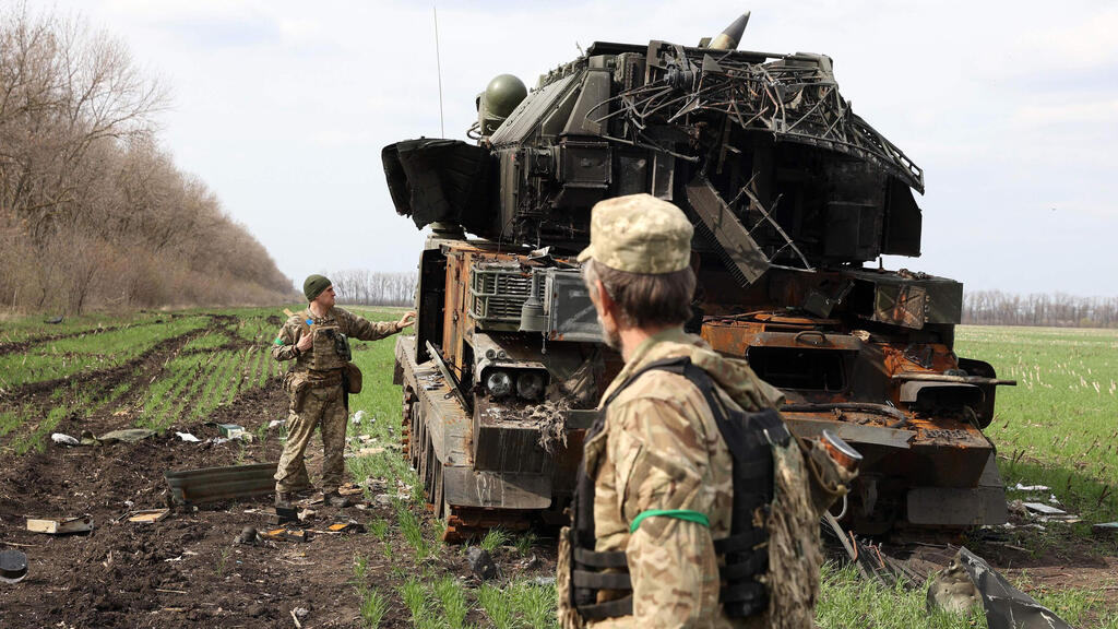 חיילים אוקראינים ליד רכב צבאי רוסי הרוס בכפר ליד חרקוב 