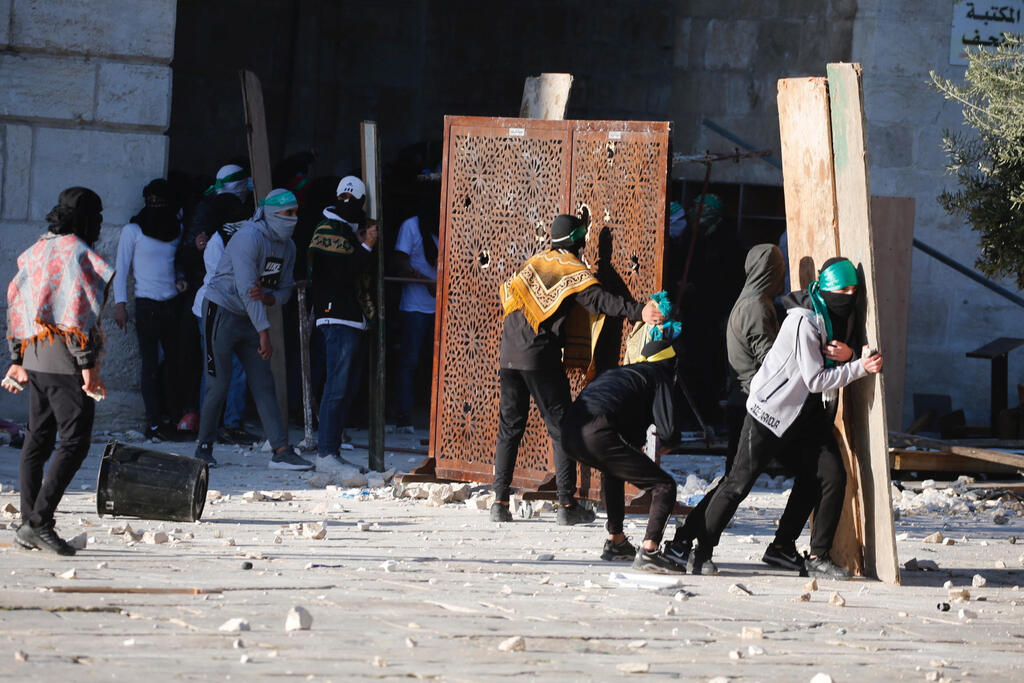 Palestinian protesters hurl stones at police forces outside the Al Aqsa Mosque in Jerusalem during clashes last Friday 