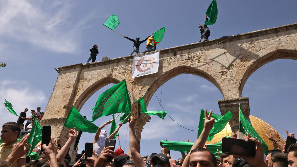 פלסטינים מנופפים בדגלי פלסטין וחמאס בהר הבית