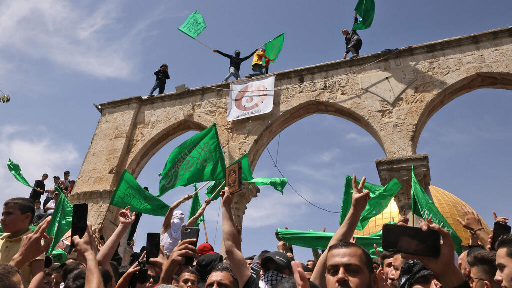 פלסטינים מנופפים בדגלי פלסטין וחמאס בהר הבית