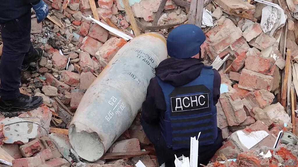  כוחות חירום אוקראינים מטפלים ב פצצה רוסית בצ'רניהיב