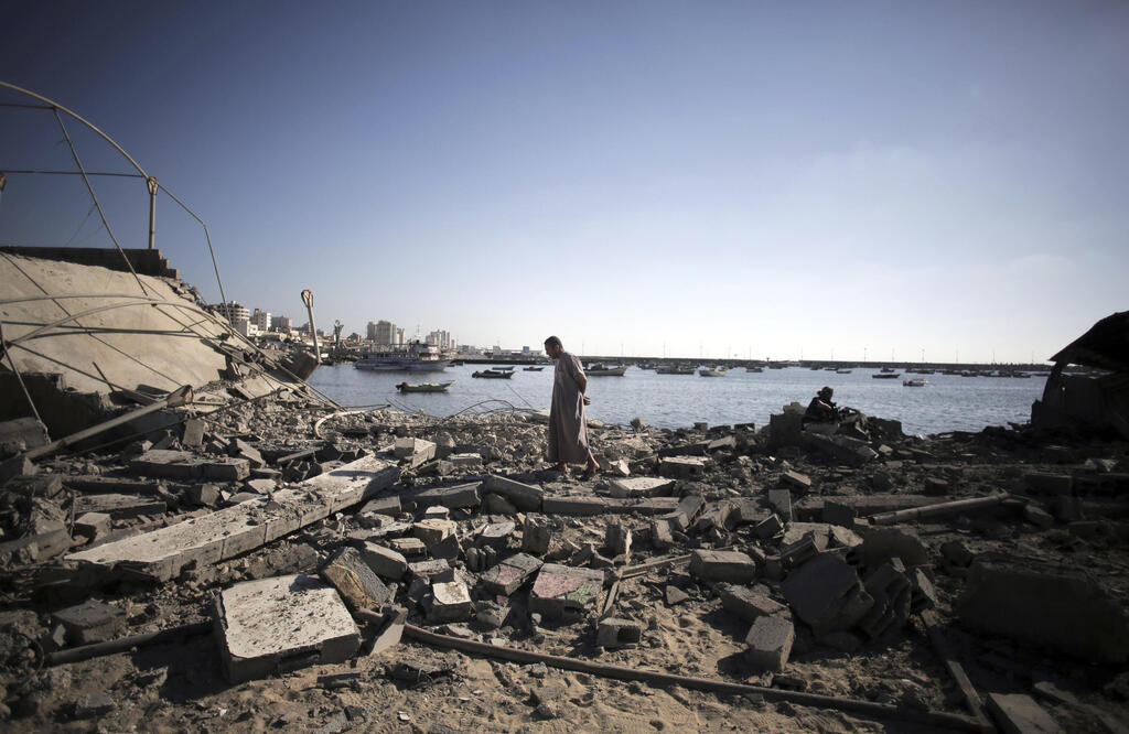A Palestinian man inspects the damage at a police post following an Israeli missile strike that killed four boys from the same extended Bakr family, in Gaza City, July 16, 2014