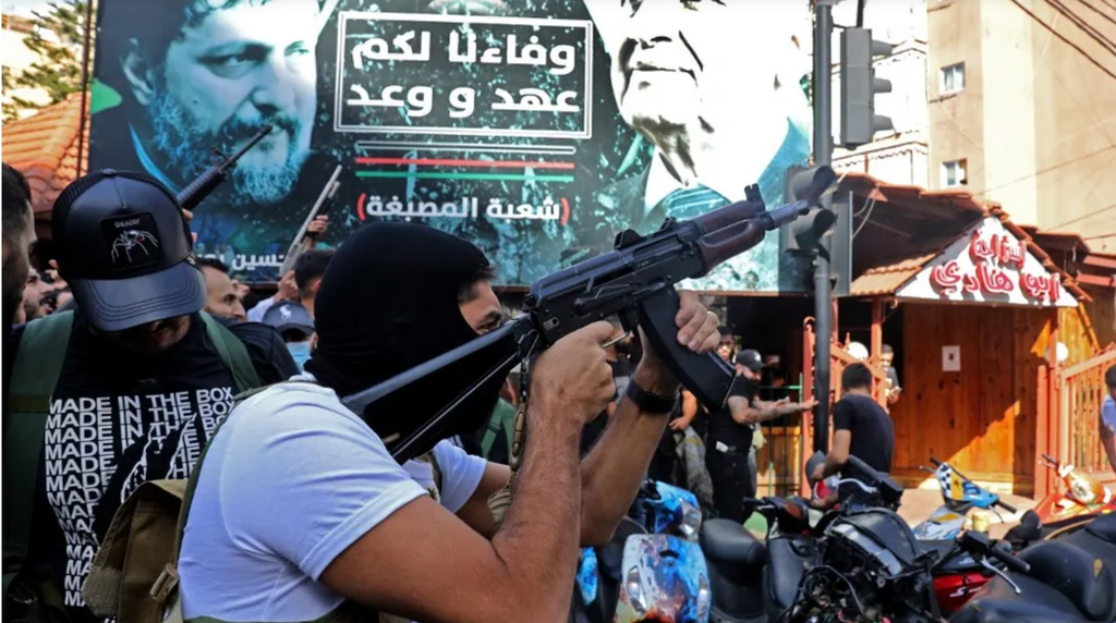A member of Hezbollah fires his gun during the funeral of some of their members who were killed a day earlier, in Beirut, Lebanon, October 15, 2021