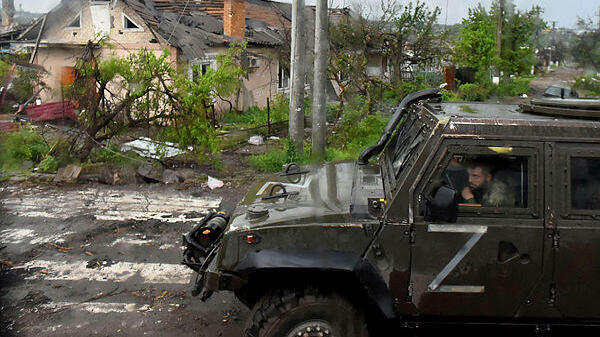 אוקראינה רכב צבאי רוסי ליד בית הרוס ב מריופול