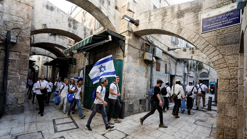 Religious youth walk with an Israeli flag through the old city of Jerusalem on Sunday ahead of the Flag March (Photo: Reuters) העיר העתיקה
