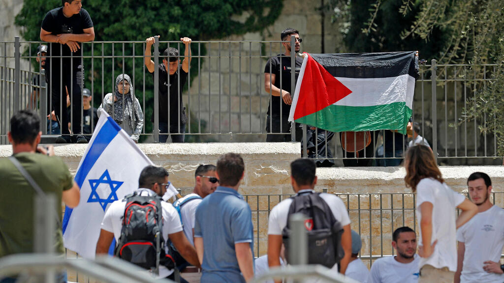 מפיגינים עם דגלי ישראל ולפסטין ליד שער שכם