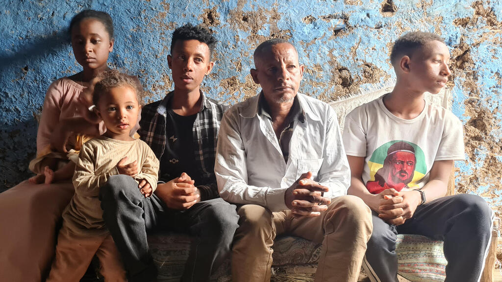 Kefale Tayachew Damtie, second from right, and his children greet visitiors to their home in Gondar, Ethiopia, May 29, 2022 