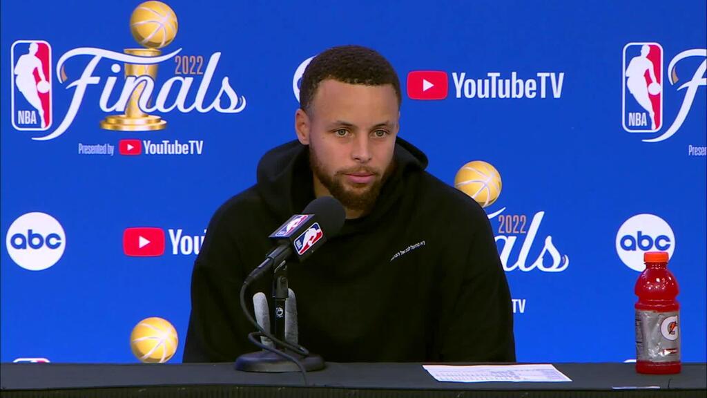 Stephen Curry sporting a sweatshirt with Hebrew on it during an NBA Finals postgame press conference